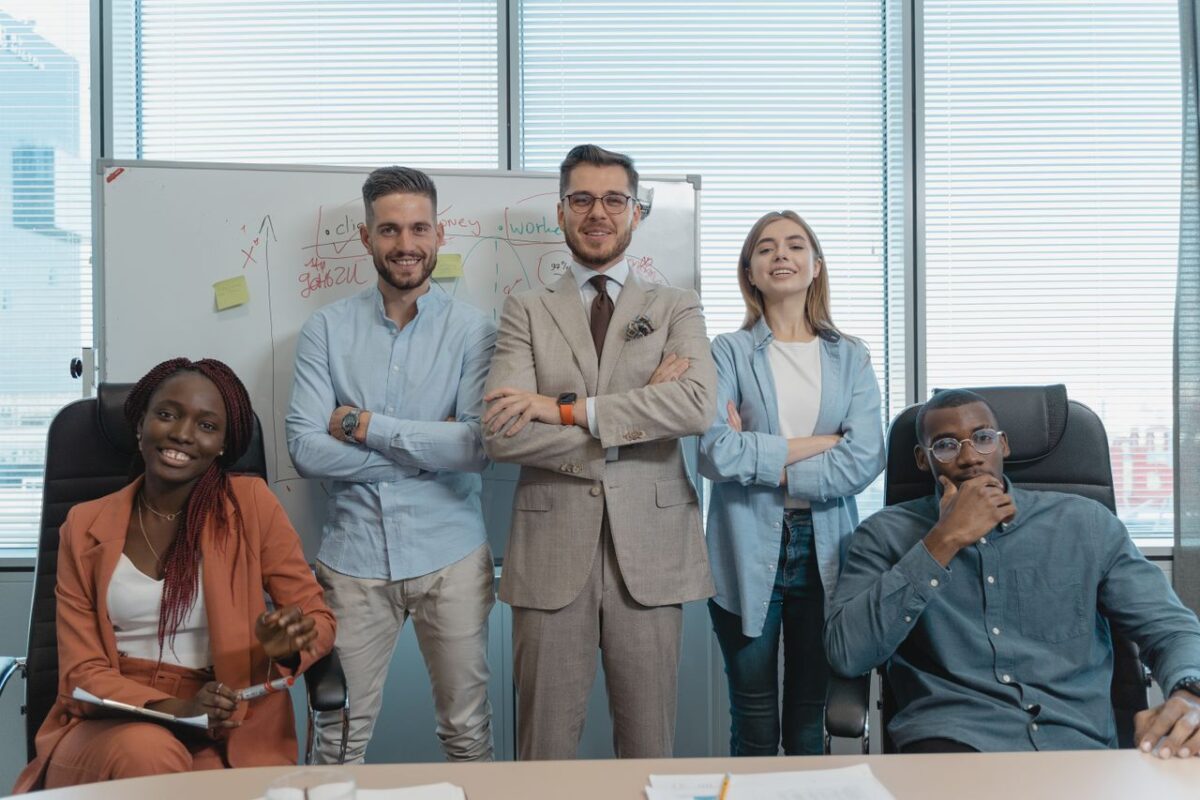 A multicultural group of business professionals confidently posing in a modern office.